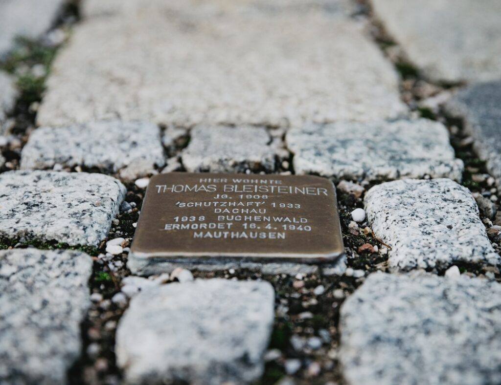 Stolperstein eingelassen zwischen Granit Kopfsteinpflaster vor dem ehemaligen Wohnsitz von Thomas Bleisteiner, in Schutzhaft 1933, Dachau, 1938 Buchenwald, 1940 ermordet in Mauthausen.