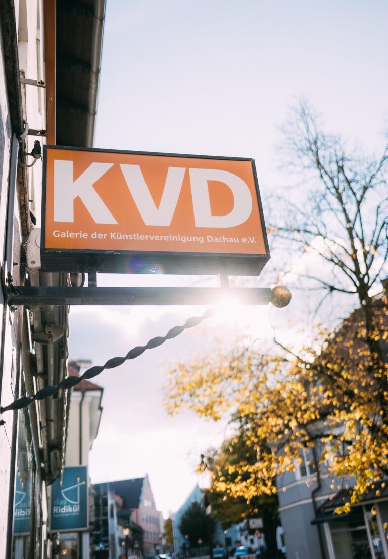 Hinweisschild auf Galerie der KVD (Künstlervereinigung Dachau) an der Hauswand zum Eingang.